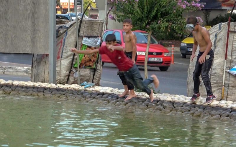 Antalya’da sıcaktan bunalan hurdacı çocuklar deniz gözlüklerini takıp soluğu süs havuzunda aldı
