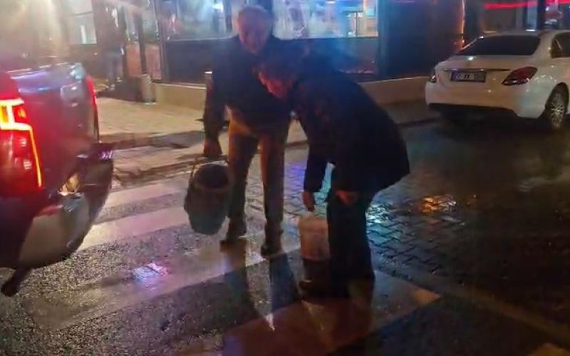 Yolda oluşan çukurları görünce dayanamayan esnaf  kum ve çakılla çukurları kendisi kapattı
