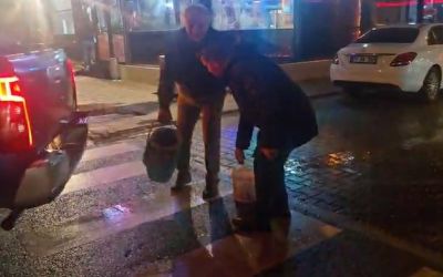 Yolda oluşan çukurları görünce dayanamayan esnaf  kum ve çakılla çukurları kendisi kapattı
